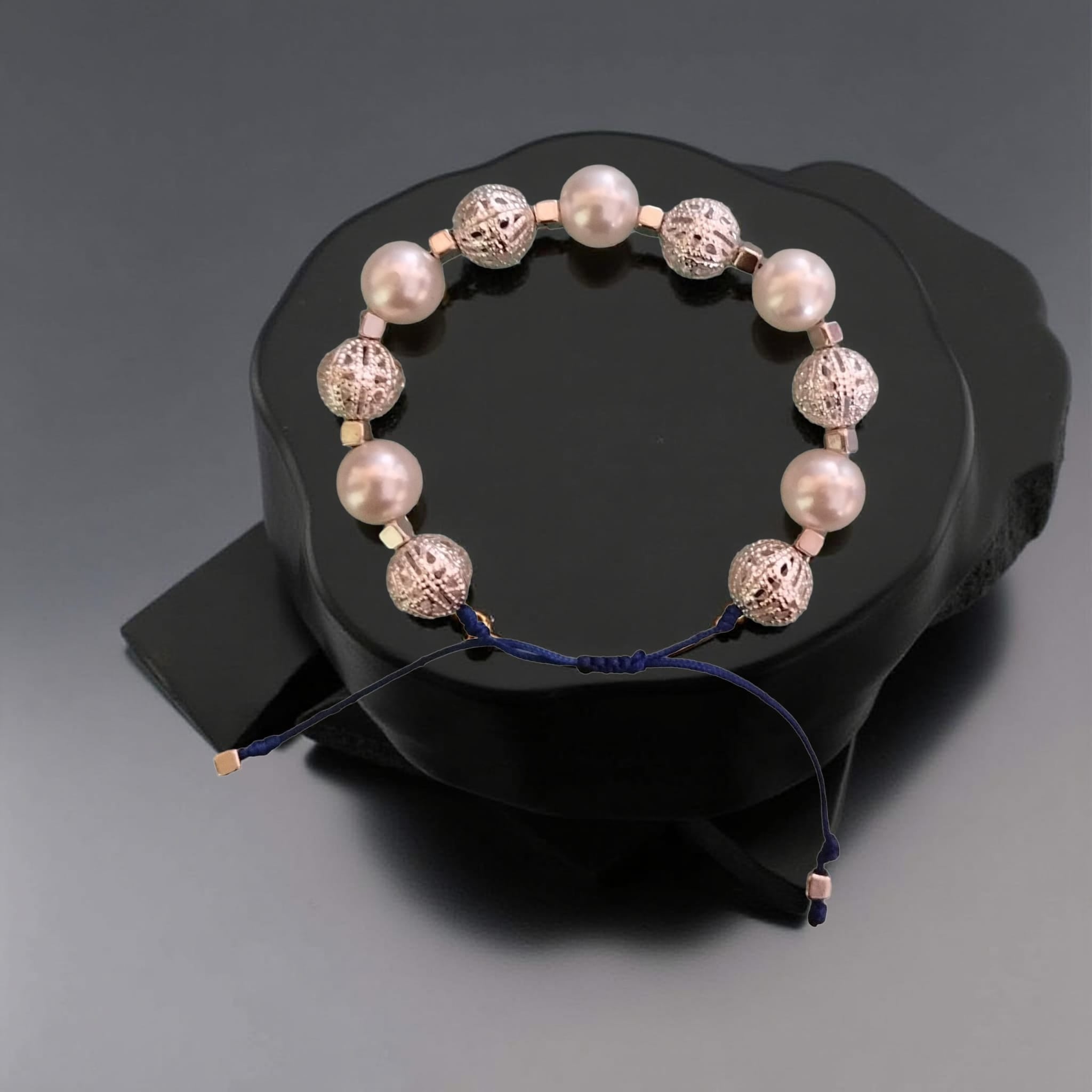 Pulsera de hilo azul con abalorios plateados y perlas