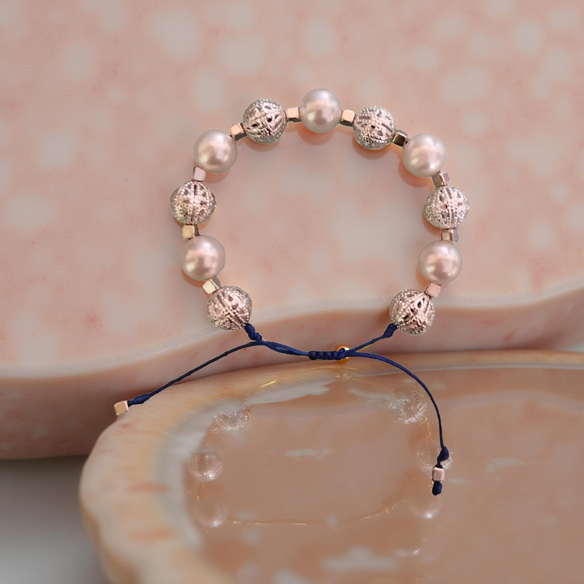 Pulsera de hilo azul con abalorios plateados y perlas
